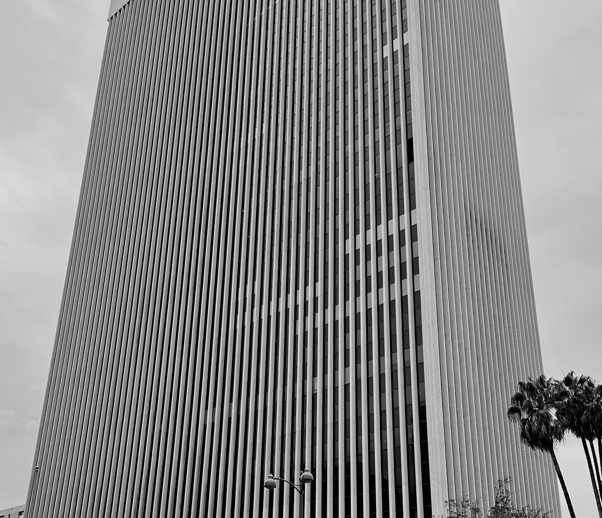 The ribbed concrete facade of Equitable Plaza, 3435 Wilshire Boulevard, palm trees below — the building where Ryu & Yun Law has its offices.
