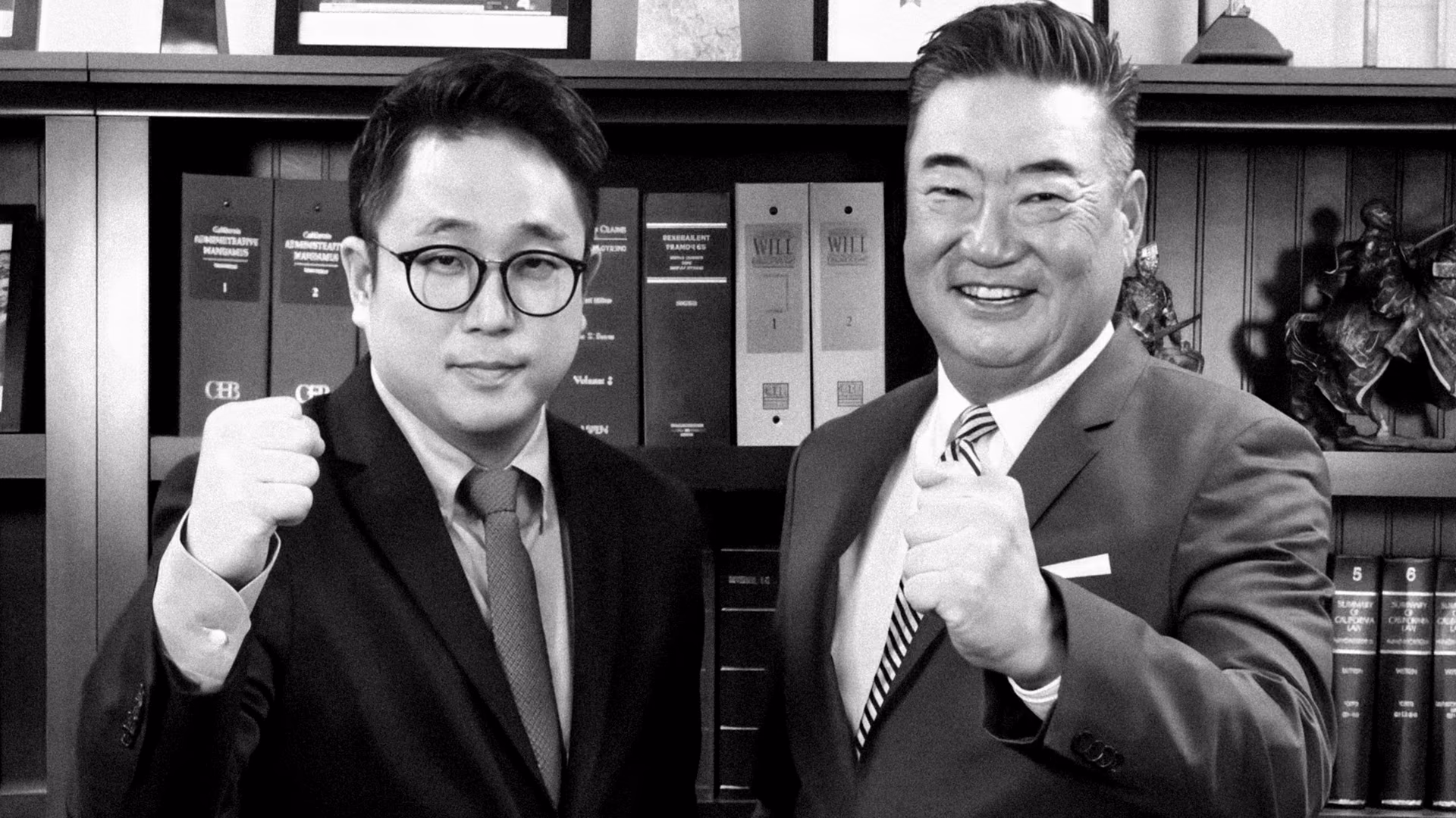 Thomas J. Ryu and Nathan S. Yun side by side in the firm's library, fists raised.